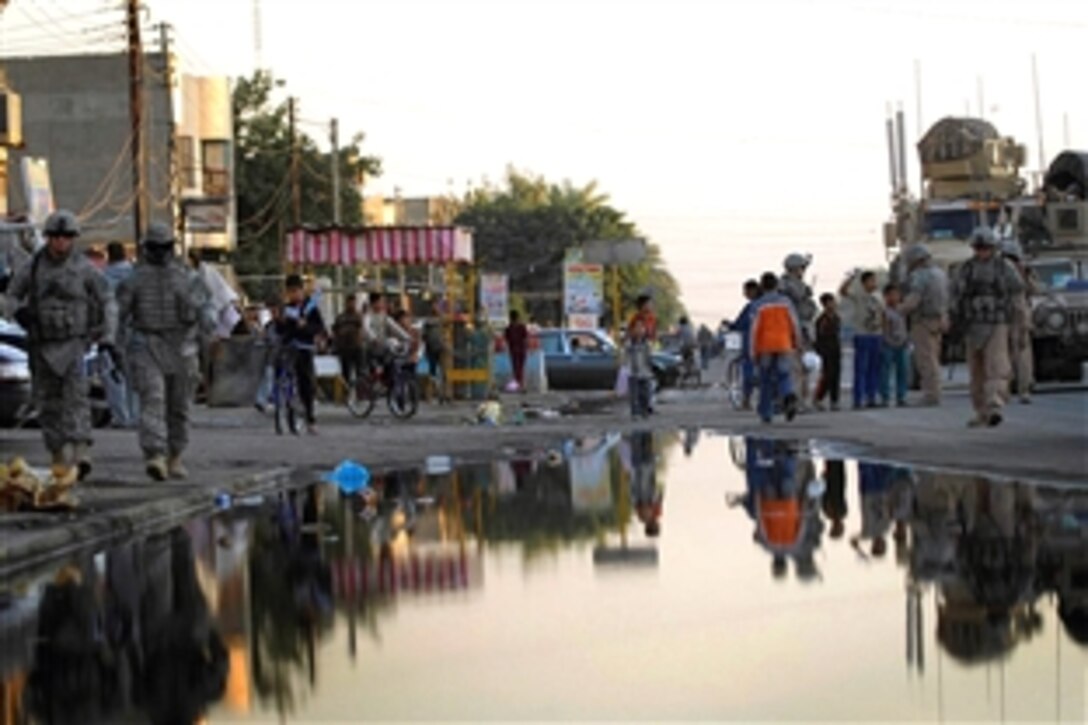 U.S. Army soldiers and U.S. Air Force airmen accompany Iraqi police officers on a walking patrol down Spruce Street handing out flags, leaflets and hanging signs in the Saydiyah community, of southern Baghdad, Iraq, Nov. 8, 2008. The soldiers are assigned to the 1st Brigade Combat Team, 4th Infantry Division and the airmen are assigned to Detachment 3, 732nd Expeditionary Security Forces Squadron.