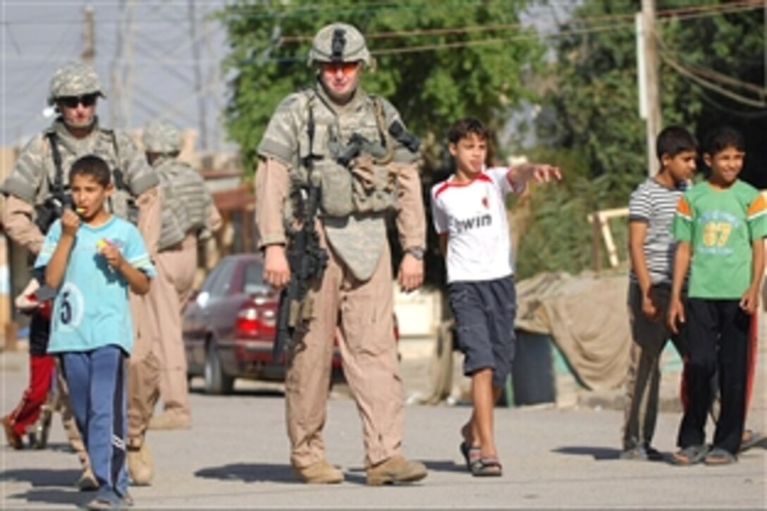 Iraqi children swarm around U.S. airmen as they accompany Iraqi police officers on a walking patrol in the Al-Bayaa community, of southern Baghdad, Iraq, Nov. 7, 2008. The airmen are assigned to Detachment 3, 732nd Expeditionary Security Forces Squadron.
