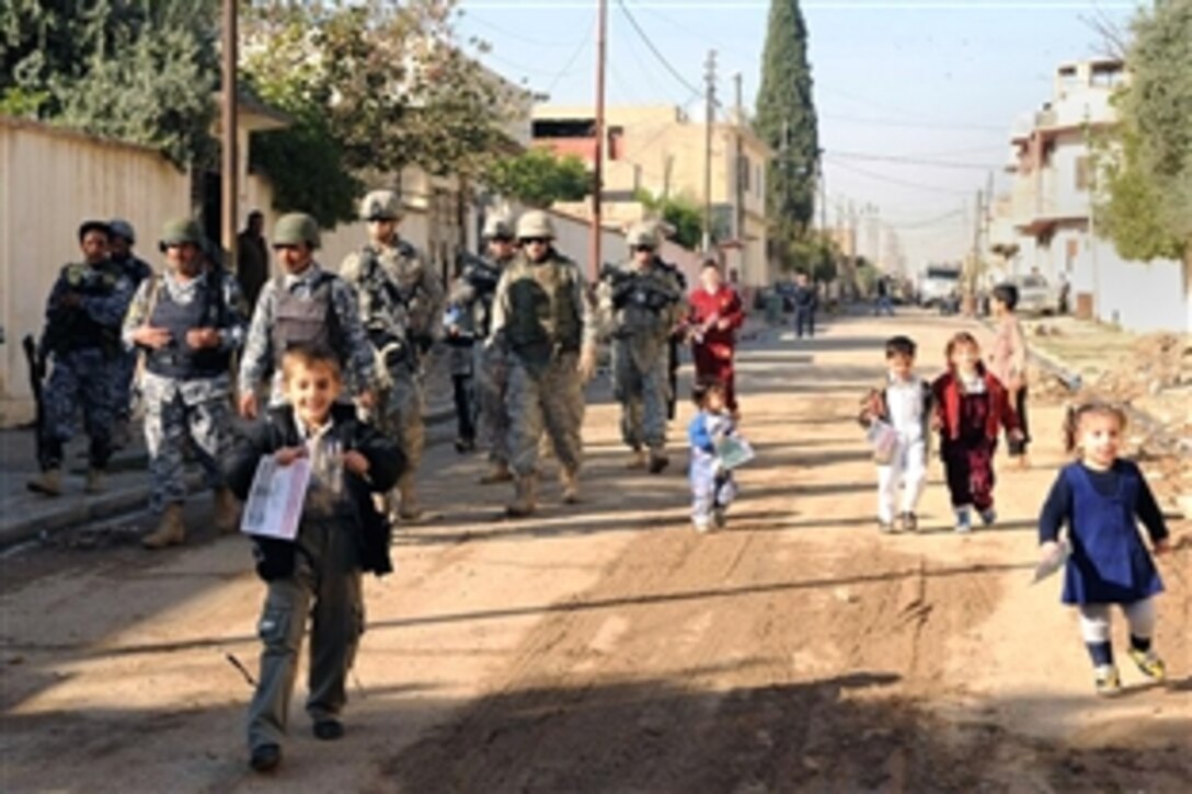Iraqi children greet U.S. Army soldiers and Iraqi National Police officers during a cordon and "knock" mission in the Thawra neighborhood of Mosul, Iraq, Nov. 8, 2008. The soldiers are assigned to the 3rd Squadron, 3rd Armored Cavalry Regiment.