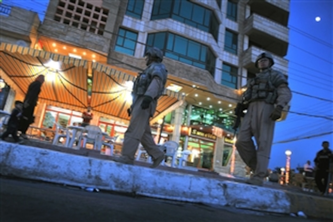 U.S. Air Force airmen accompany Iraqi police officers on a walking patrol down Spruce Street handing out flags and leaflets, and hanging signs in the Saydiyah community of southern Baghdad, Iraq, Nov. 8, 2008. The airmen are assigned to the 4th Infantry Division's Detachment 3, 732nd Expeditionary Security Forces Squadron, 1st Brigade Combat Team.