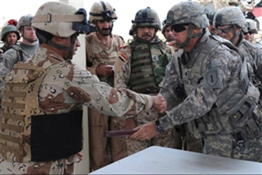 U.S. Army Lt. Col. Doughton shakes hands with an Iraqi soldier as he hands him an award for excellence in training at the Bessimayah Range, Iraq, Oct. 31, 2008.  Doughton is assigned to the 25th Infantry Division's 2nd Stryker Brigade Combat Team. 
