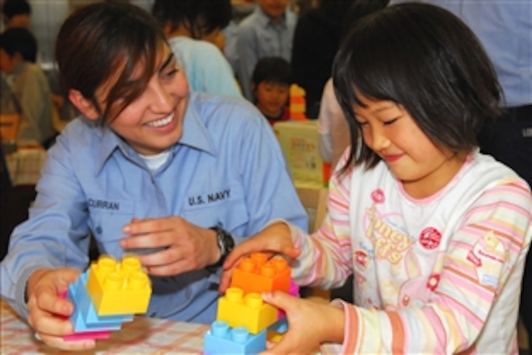 U.S. Navy Seaman Zandria Curran, assigned to the Arleigh Burke-class guided-missile destroyer USS Curtis Wilbur, plays with a child at the Fukuoka Kodomo no Ie Children's Home in Fukuoka, Japan, Nov. 8, 2008. Sailors assigned to the ship are visiting the children's home as part of a community relations project.