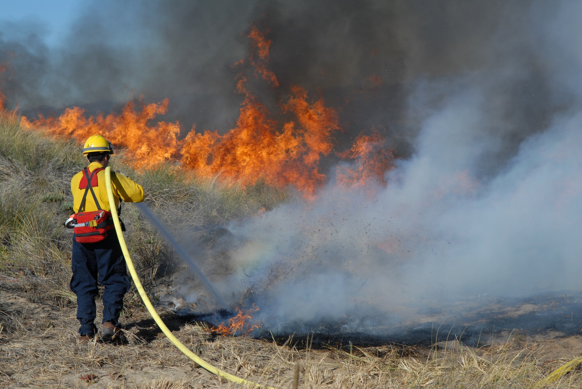 VANDENBERG AIR FORCE BASE, Calif.  -- A Firefighter from the 30th Civil Engineer Squadron extinguishes some of the fire during a controlled burn to help enlarge the habitat for an endangered species of Western Snowy Plovers here Nov. 6.  (U.S. Air Force photo/Airman 1st Class Antoinette Lyons)
