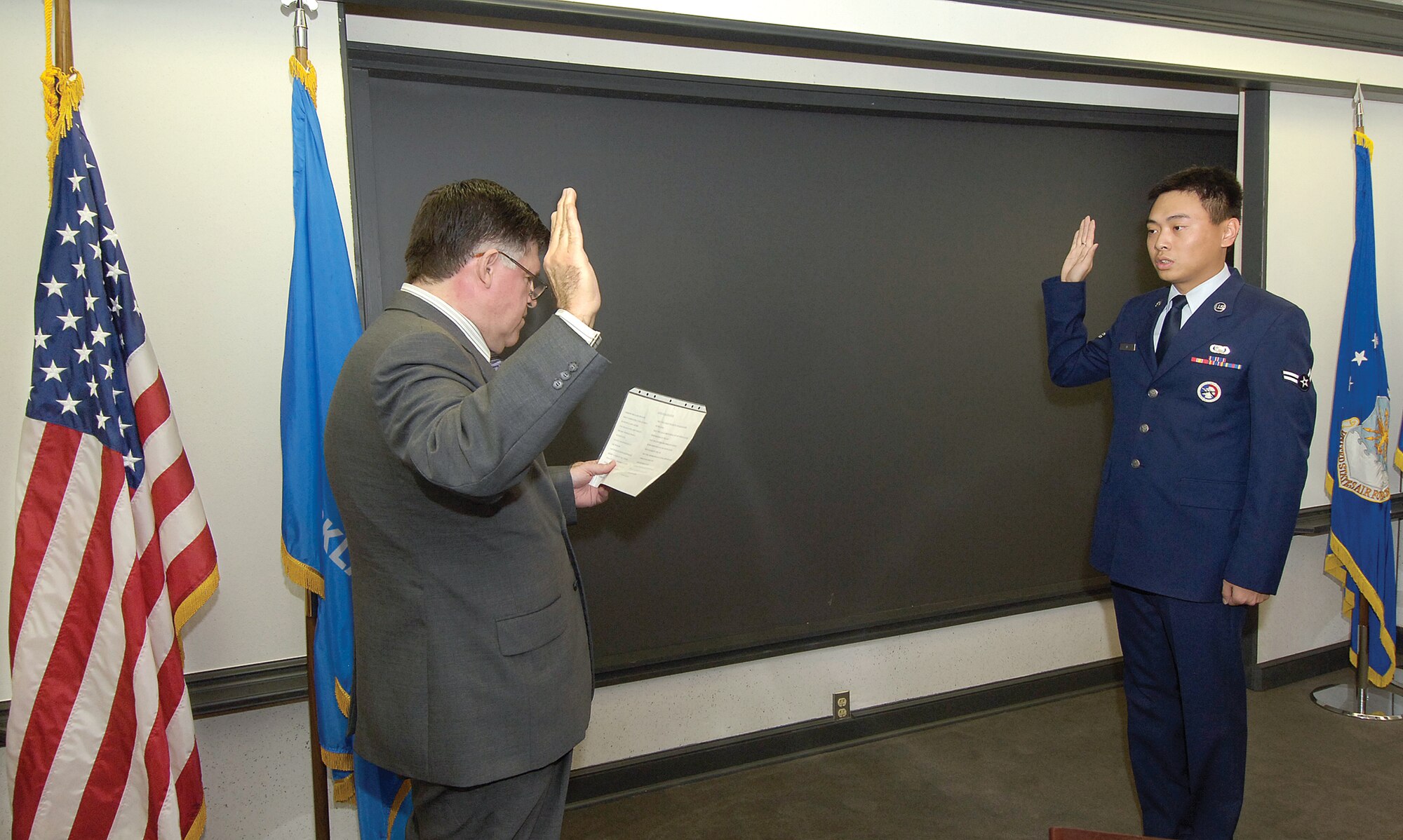 After waiting more than two years and almost giving up hope, Airman 1st Class Zhenhua Xie becomes a United States citizen in a Nov. 6 ceremony at Tinker. Supportive friends and co-workers packed a Bldg. 460 conference room to watch the 72nd Force Support Squadron information manager and Tinker Honor Guard member recite the oath given by Jose Olivares of the U.S. Citizenship and Immigration Services. Mr. Olivares made a special trip to Tinker to perform the ceremony.  (Air Force photo/Margo Wright)