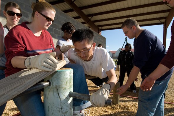 Civilian Acculturation and Leadership Training student Jana Ramon assists fellow student Eric Chan during a physical problem-solving exercise at Maxwell’s Project-X training facility Nov. 3. Activities at Project-X were just one of many elements of training CALT students received during their two weeks at Maxwell’s Officer Training School. (Air Force photo by Jamie Pitcher)
