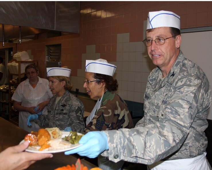 WRIGHT-PATTERSON AFB, Ohio - Col. Stephen Goeman, 44th Airlift Wing commander, Master Sgt. Denise Williams, 445th Airlift Wing first sergeant, and Command Chief Patricia Thornton, 4th Air Force, serve Thanksgiving dinner at the Pitsenbarger Dining Hall Nov. 2, 2008.  It is a tradition for wing leadership to serve meals during the holiday season to 445th Airlift Wing reserve members to show appreciation for their hard work throughout the year. (Air Force photo/Maj. Jose Cardenas)   