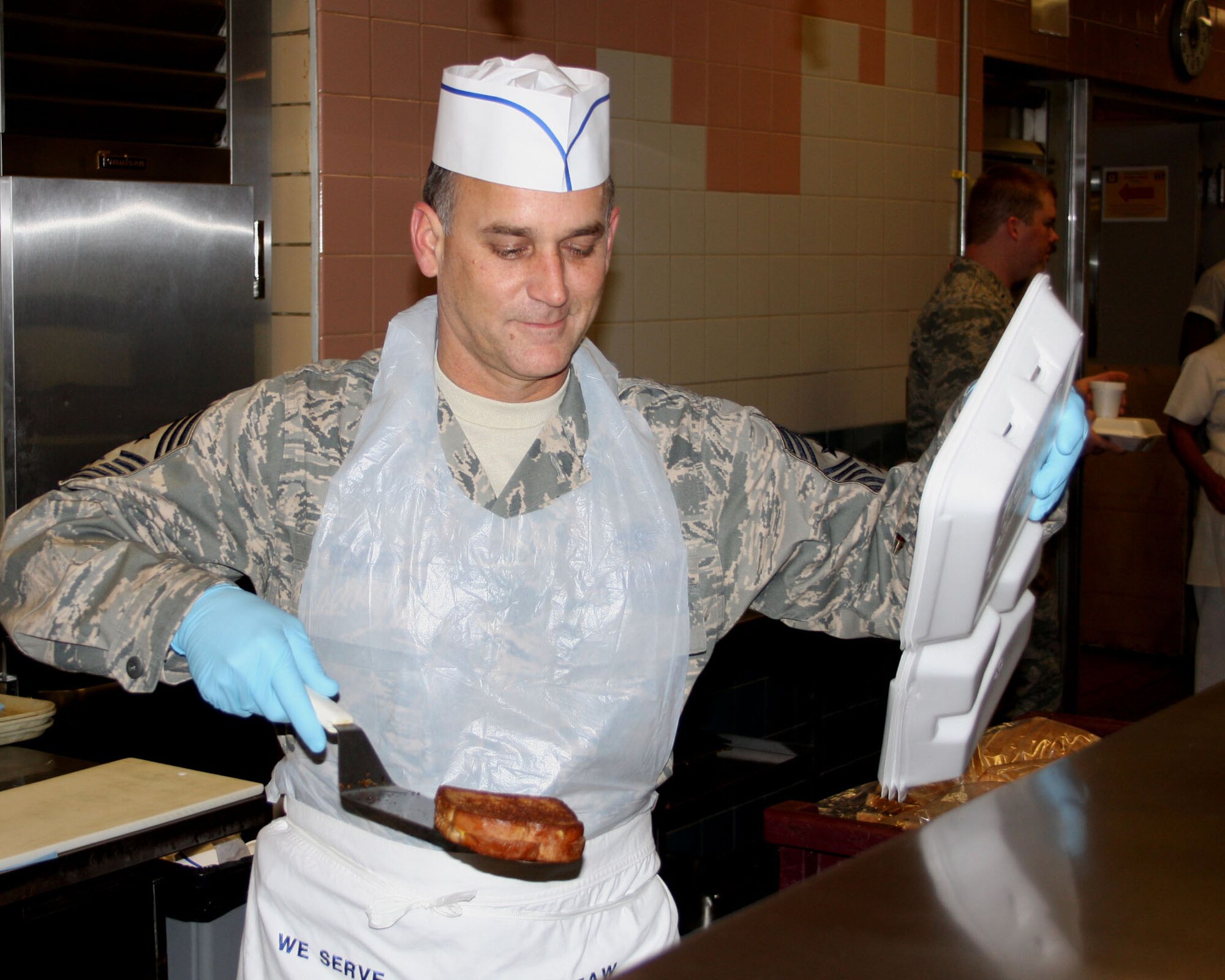 WRIGHT-PATTERSON AFB, Ohio - Command Chief Aaron Mouser, 44th Airlift Wing, helps serve Thanksgiving dinner at the Pitsenbarger Dining Hall Nov. 2, 2008.  It is a tradition for wing leadership to serve meals during the holiday season to 445th Airlift Wing reserve members to show appreciation for their hard work throughout the year. (Air Force photo/Maj. Jose Cardenas)   