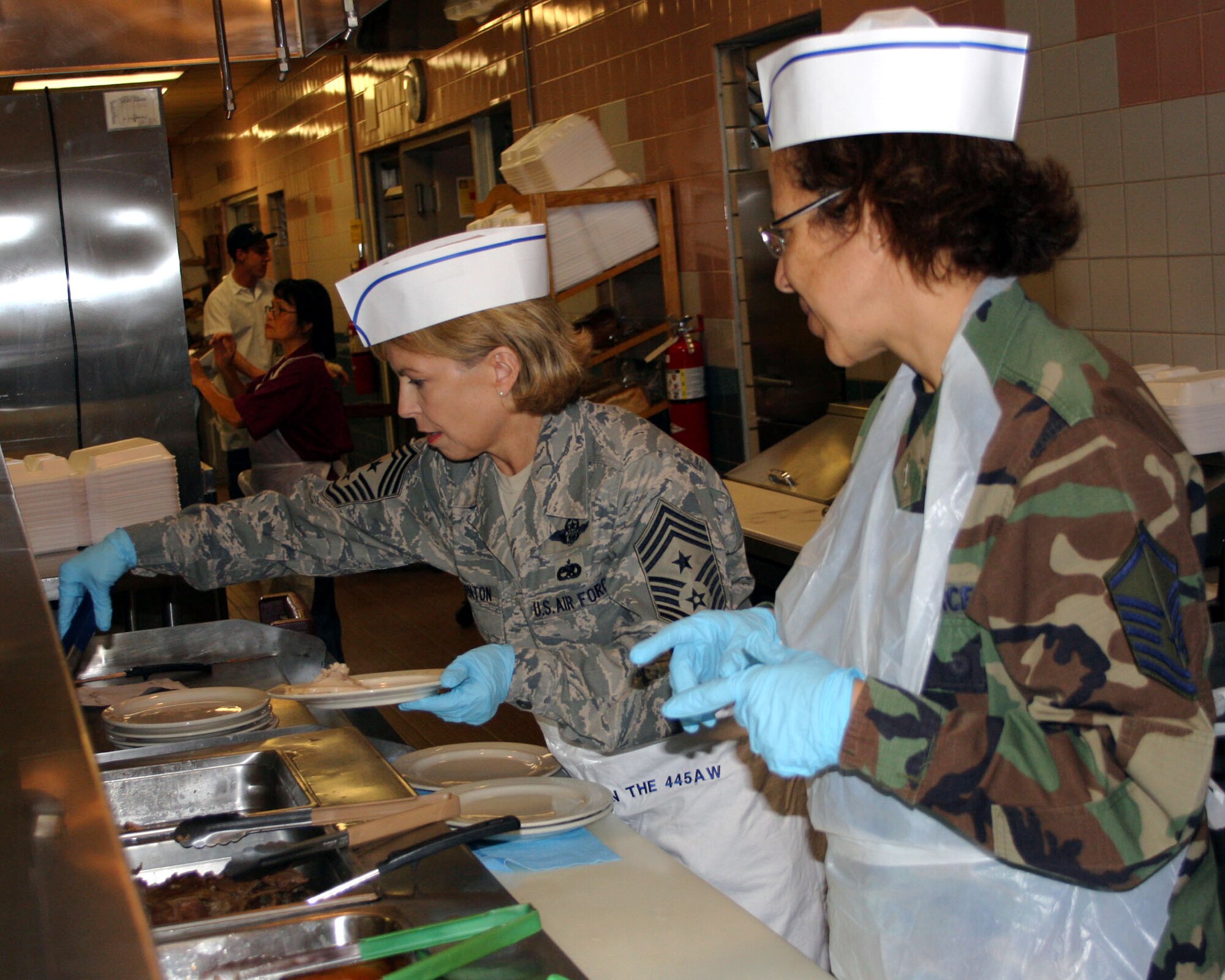 WRIGHT-PATTERSON AFB, Ohio - Command Chief Patricia Thornton, 4th Air Force, helps serve Thanksgiving dinner at the Pitsenbarger Dining Hall Nov. 2, 2008 as Master Sgt. Denise Williams, 445th Airlift Wing First Sergeant, looks on.  It is a tradition for wing leadership to serve meals during the holiday season to 445th Airlift Wing reserve members to show appreciation for their hard work throughout the year. (Air Force photo/Maj. Jose Cardenas)   