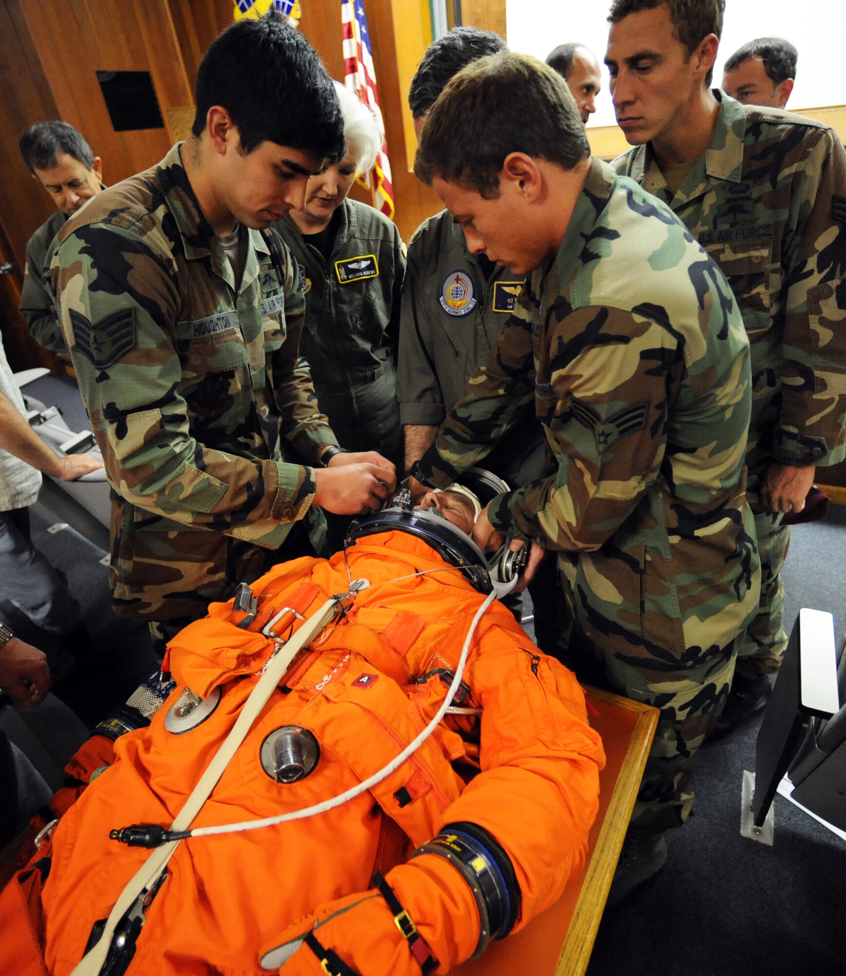 PATRICK AIR FORCE BASE, Fla. -- Pararescuemen from the 38th Rescue Squadron at Moody AFB, Ga., familiarize themselves with the Advanced Crew Escape Suit (ACES) at the helicopter squadron here in preparation for tomorrow's space shuttle launch. The spacesuit, also known as the "pumpkin suit," contains such items as a signal flare, survival radio, strobe light, drinking water, motion-sickness pills and a one-man life raft. Reserve, Guard and active-duty pararescuemen have provided medical contingency response for all manned and unmanned NASA launches since the space program began. (U.S. Air Force photo/Tech. Sgt. Paul Flipse)