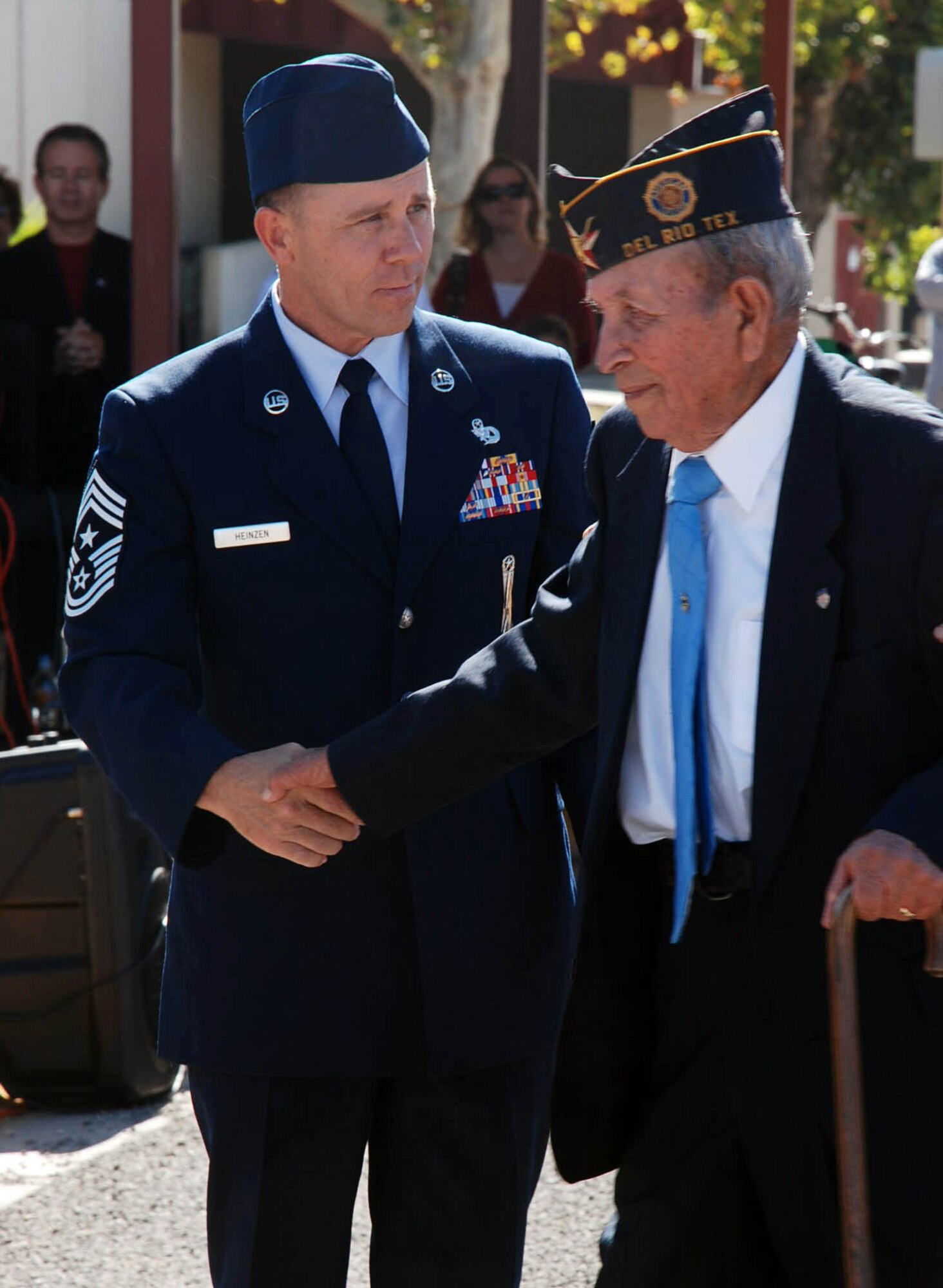 LAUGHLIN AIR FORCE BASE, Texas – Chief Master Sgt. Bruce Heinzen, 47th Flying Training Wing command chief, helps a local World War II Veteran walk to the front of the crowd to be honored during the annual Veteran’s Day ceremony in Del Rio November 11.  A four-ship formation of T-6 Texan IIs kicked off the ceremony that honored generations of American veterans. (U.S. Air Force photo by Airman 1st Class Sara Csurilla)