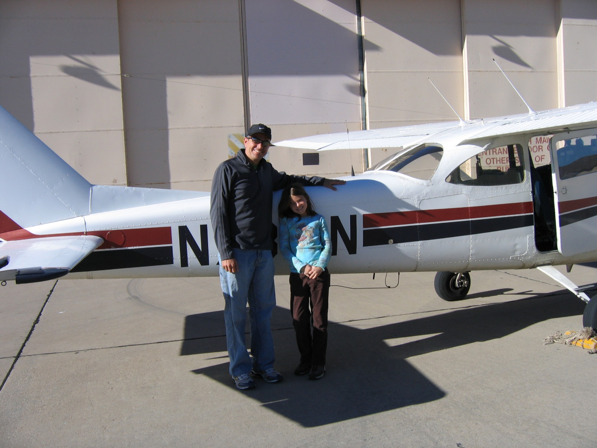 Capt. Jose Gutierrez, 586 Flight Test Squadron, poses with Samantha McGee, daughter of Col. Michael McGee, 49th Fighter Wing vice commander, after returning from her first flight over Alamogordo, N.M., at the Aero Club at Holloman Air Force Base, N.M., Oct. 22. (Photo provided)