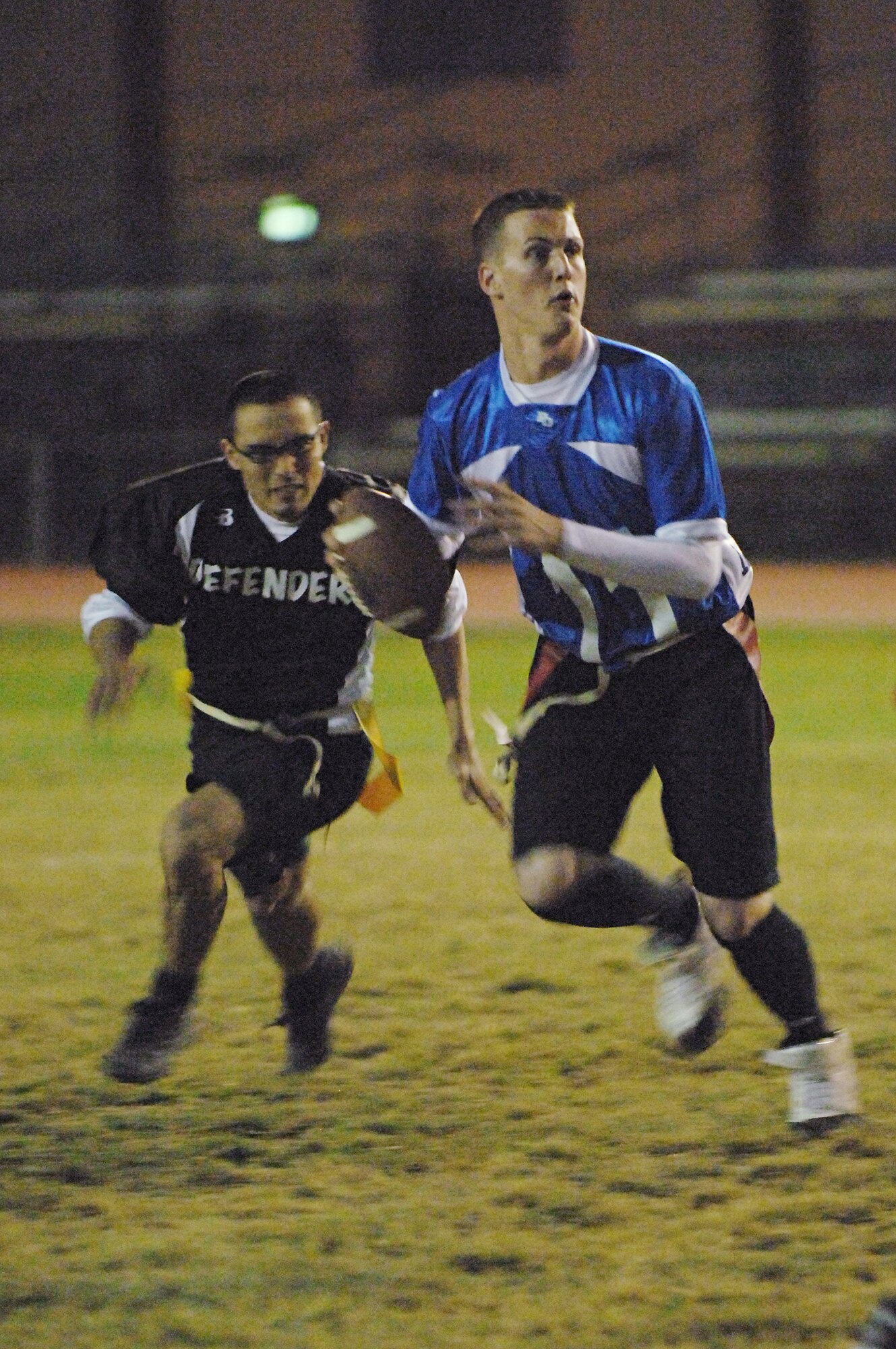 Richard Powell, 728th Air Mobility Squadron, scans down-field for an open receiver as Joel Cerdan, 39th Security Forces Squadron Defenders, rushes in for a sack. (U.S. Air Force photos by Senior Airman Benjamin Wilson)