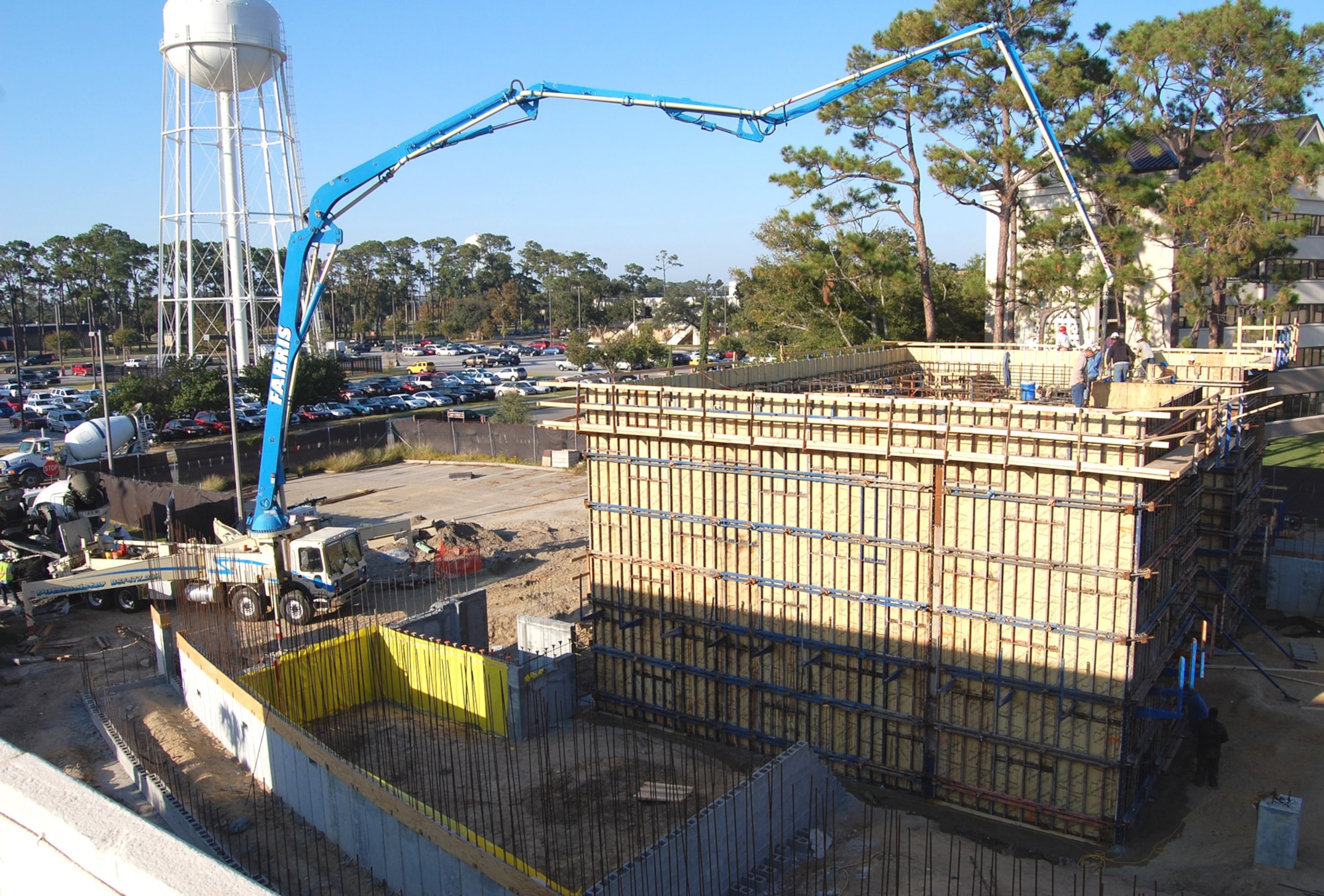 Construction workers pour concrete for the linear accelerator vault walls at Keesler Medical Center’s new diagnostic imaging center Sept. 30.  James Martin, Air Force Civil Engineering Support Agency Katrina Recovery project manager, said the reinforced concrete walls are 2-3 feet thick and about 23 feet high.  A convoy of cement trucks made dozens of trips throughout the day to pour about 698 cubic yards of concrete using two large pumping booms. Construc-tion is about 13 percent complete.  July 1 is the scheduled occupancy date.  (U.S. Air Force photo by Steve Pivnick)