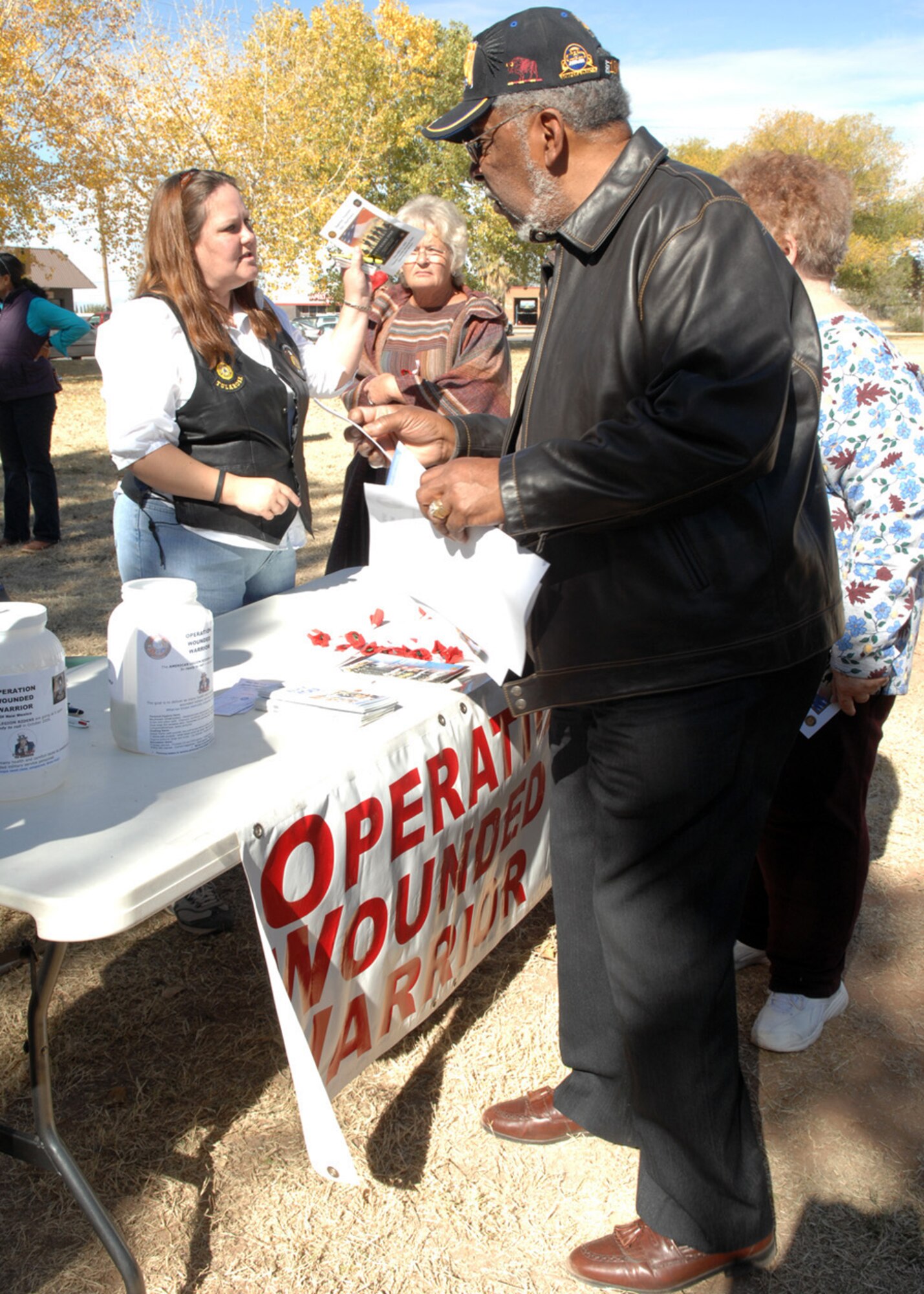 Operation Wounded Warrior representatives hand out information about their supporting cause to help all military members at the Tularosa Veterans Day Memorial Park, N.M., Nov. 11. The Tularosa community attended the Veterans Day Observance to honor all veterans. (U.S. Air Force photo/Airman 1st Class Veronica Salgado)