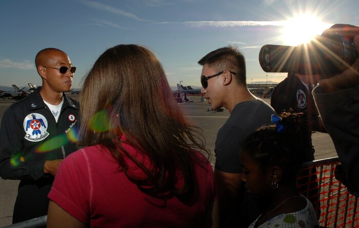 Staff Sgt. Harvey McReynolds (left), U.S. Air Force Air Demonstration Squadron, The Thunderbirds, assistant crew chief for the thunderbird four jet, greets fans during the air show at Nellis Air Force Base, Nev., Nov. 8, 2008. The Nellis AFB air show showcased the 21st-century Air Force’s capabilities in air, space and cyberspace. The show, held Nov. 8-9. is the largest aviation event in Las Vegas and the largest free public event in Nevada.(U.S. Air Force Photo/Senior Airman Larry E. Reid Jr.)