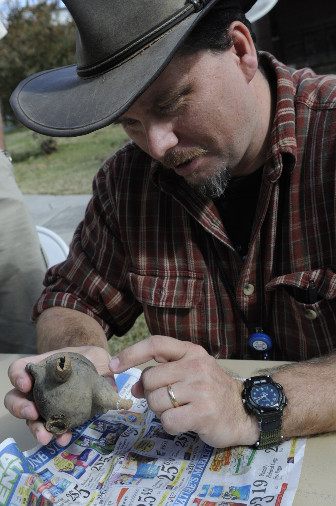 Stephen Hammack examines a piece of pottery brought in by Steve Taylor, 569th ACSS to try to determine its age during the artifact ID. U. S. Air Force photo by Sue Sapp