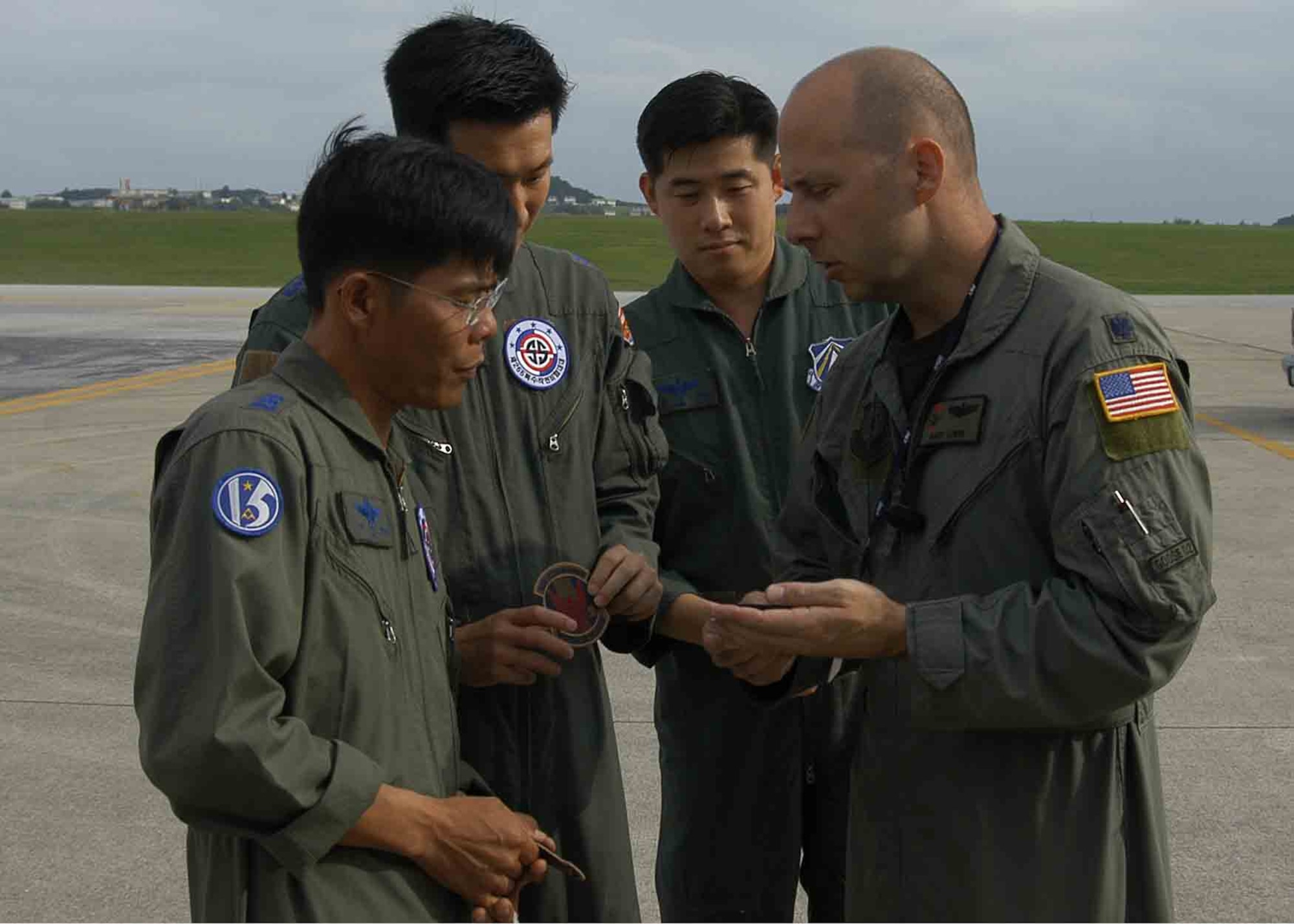 KADENA AIR BASE, Japan -- From right: Lt. Col. Andrew Lewin, 1st Special Operations Squadron director of operations, discusses the significance of the 1st SOS patch with Republic of Korea Air Force, or ROKAF, Maj. Eui Sik Kim, ROKAF Operations Command, ROKAF Capt. Seung Hyun Kim, 255th Special Operations Squadron, and ROKAF Lt. Col. Gye Sam Lee, the 255th SOS commander, before a flight aboard a 1st SOS MC-130H Combat Talon II here Nov. 4. Col. David Mullins, the 353rd Special Operations Group commander, invited the ROKAF members to visit Nov. 3 -6 to see how the group trains, equips and coordinates its MC-130 aircrews.  The 353rd SOG and 255th SOS are both part of the Combined Joint Special Operations Air Component which supports special operations missions in the Pacific. (U.S. Air Force photo by Tech. Sgt. Aaron Cram)                                 