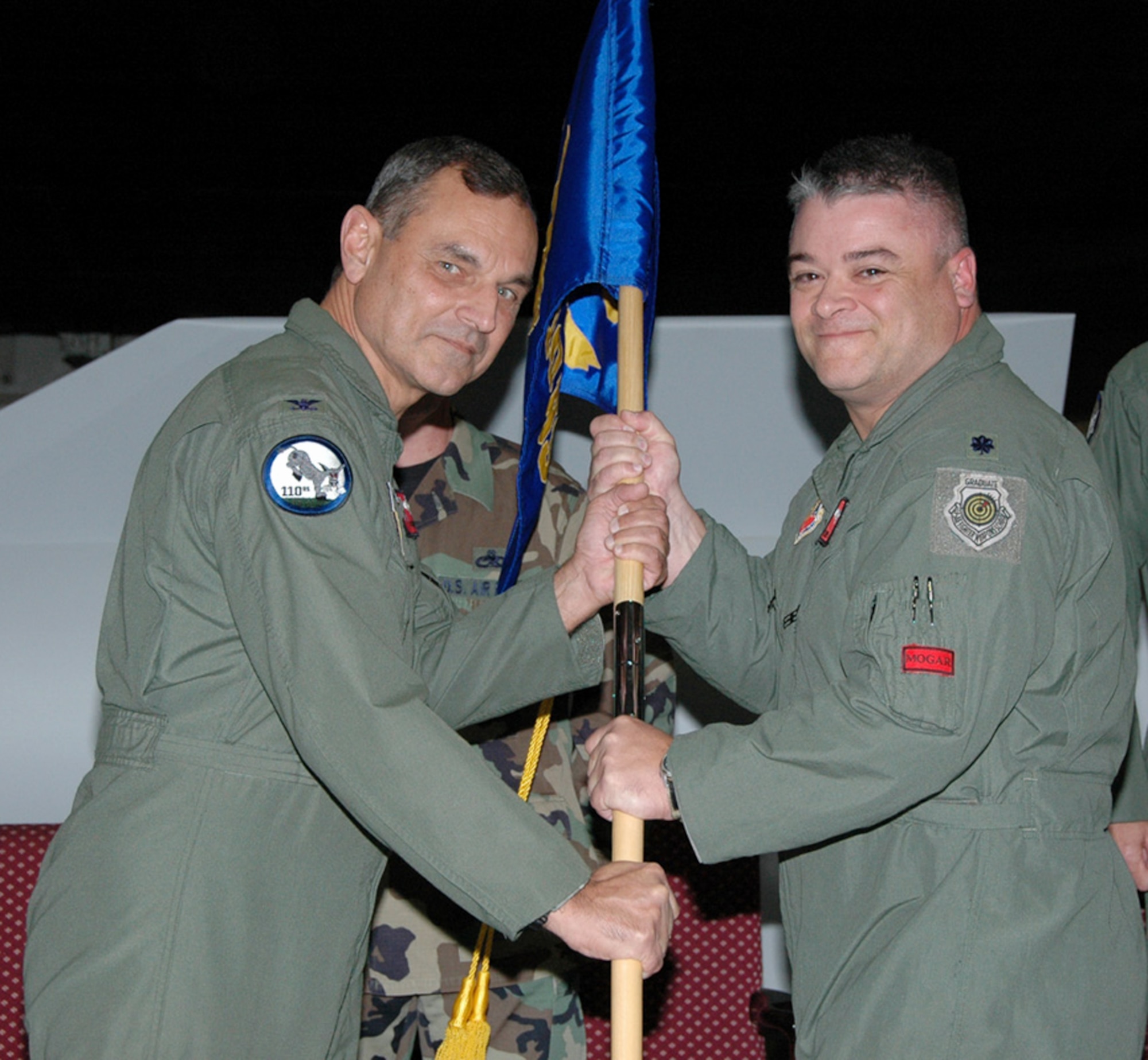 Col. Robert Leeker, 131st Bomb Wing commander, presents the gideon to Lt. Col. Kenneth "Willie B" Eaves, former 131st Fighter Wing chief of plans and programs and total force integration officer, to signify Colonel Eaves assumption of command of the 110th Bomb Squadron during a ceremony at Whiteman AFB Nov. 7.  Colonel Leeker explained, the assumption of command is the first for the 131st Bomb Wing at Whiteman AFB, first of many. (Photo by Master Sgt. Mary-Dale Amison)