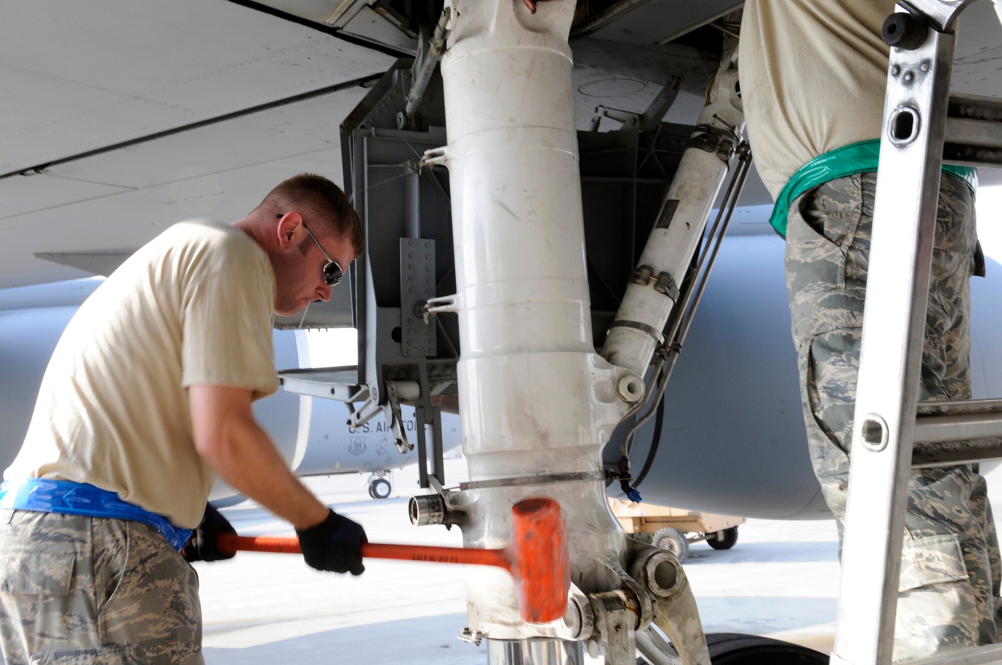 Staff Sgt. Jason Lucius, aircraft maintenance craftsman assigned to the 379th Expeditionary Aircraft Maintenance Squadron, pounds on a landing gear strut of a KC-135 Stratotanker, Nov. 12, at an undisclosed air base in Southwest Asia.  The strut is lowered with a couple of helpful strikes from a 10.5 pound dead blow mallet.  The strut has to be lowered to remove and replace it.  Stratotankers provide the core aerial refueling capability for the Air Force, Navy, Marine Corps and allied nation aircraft operating in the Central Command area of responsibility.  Sergeant Lucius is a native of Cincinnati, Ohio, and is deployed from McConnell Air Force Base, Kan., in support of Operations Iraqi and Enduring Freedom and Joint Task Force-Horn of Africa.  (U.S. Air Force photo by Tech. Sgt. Michael Boquette/Released)