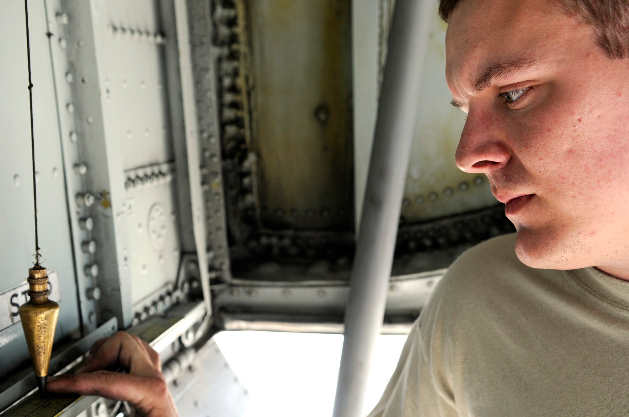 Senior Airman Robert Lewis, aircraft maintenance journeyman assigned to the 379th Expeditionary Aircraft Maintenance Squadron, watches a plumb bob ton ensure a KC-135 Stratotanker remains level as it is raised on jacks, Nov. 12, at an undisclosed air base in Southwest Asia.  The KC-135 is being jacked up for a landing gear strut replacement.  Stratotankers provide the core aerial refueling capability for the Air Force, Navy, Marine Corps and allied nation aircraft operating in the Central Command area of responsibility. Airman Lewis hails from Kilbourne, La., and is deployed from McConnell Air Force Base, Kan., in support of Operations Iraqi and Enduring Freedom and Joint Task Force-Horn of Africa.  (U.S. Air Force photo by Tech. Sgt. Michael Boquette/Released)