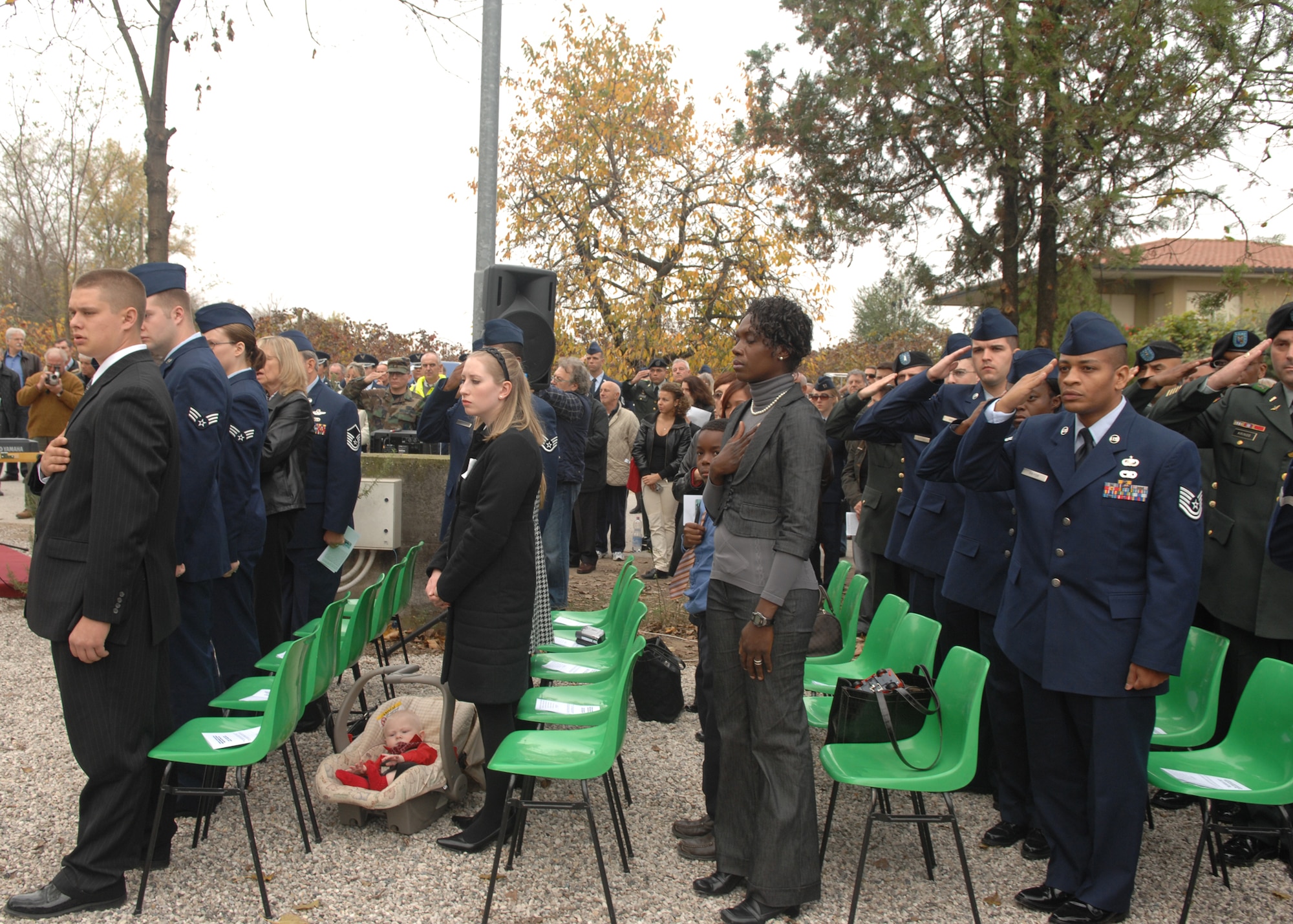 Family members and survivors of the UH-60 Helicopter crash that happened in Santa Lucia di Piave, Italy, on Nov. 8, 2007 render the proper respect during the playing of  the Italian and American national anthems. Members of the Aviano Air Base and Santa Lucia di Piave communities gathered together to commemorate the one year anniversary of the crash on Nov. 8 in Santa Lucia di Piave, Italy, and unveil a memorial dedicated in their memory. (U.S. Air Force photo/Senior Airman Taylor Marr)