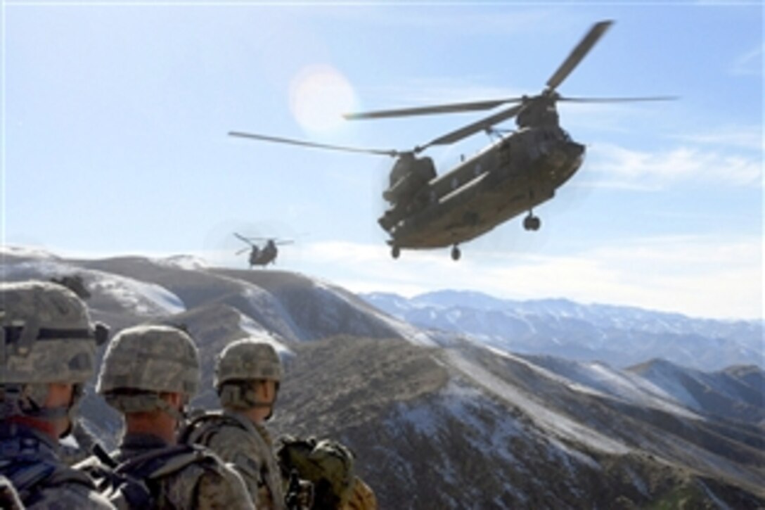 Standing by on a hill top, soldiers with the 101st Division Special Troops Battalion, 101st Airborne Division watch as two Chinook helicopters fly in to take them back to Bagram Air Field, Afghanistan, Nov. 4, 2008. The soldiers searched a small village in the valley below for improvised explosive device-making materials and facilities.