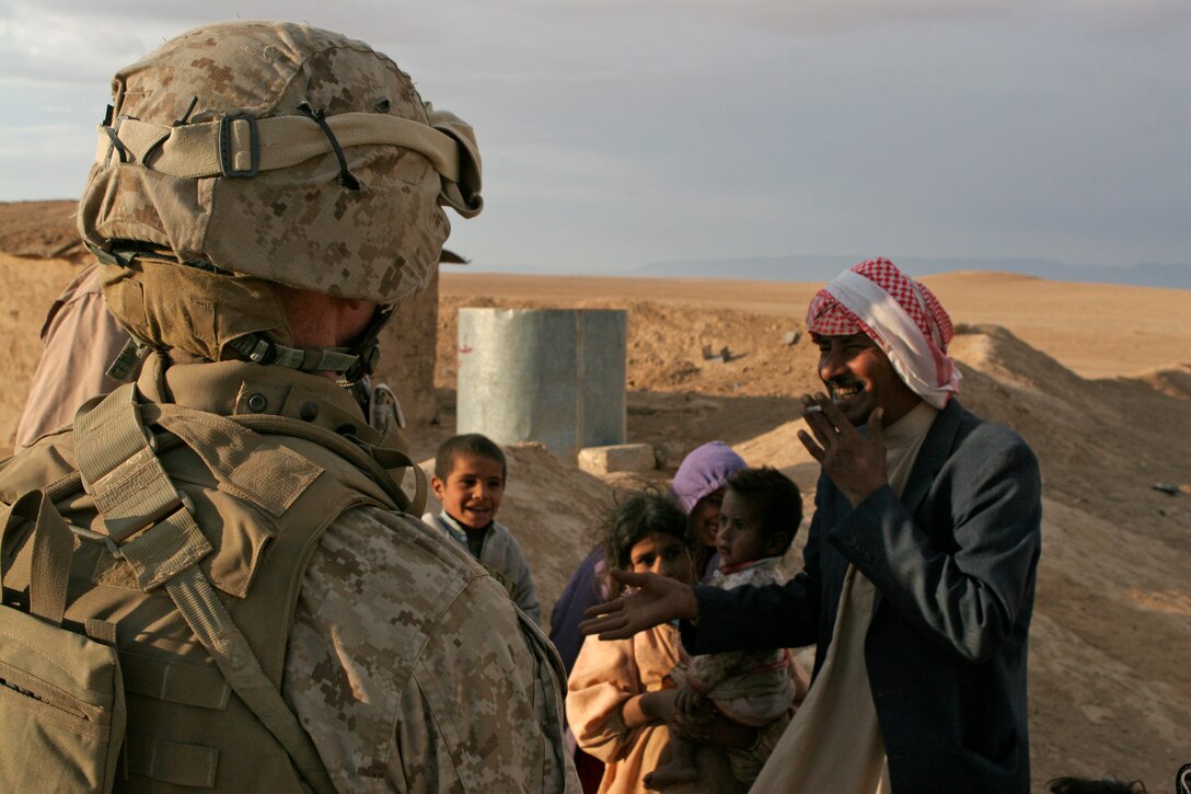 Lt. Col. Andrew J. Drake, plans officer, Jump command point, Multi National Force - West, speaks to an Iraqi man and his family in the countryside outside Al-Ba'aj, during a visit to promote good relationships and security for the Marines and Iraqis.