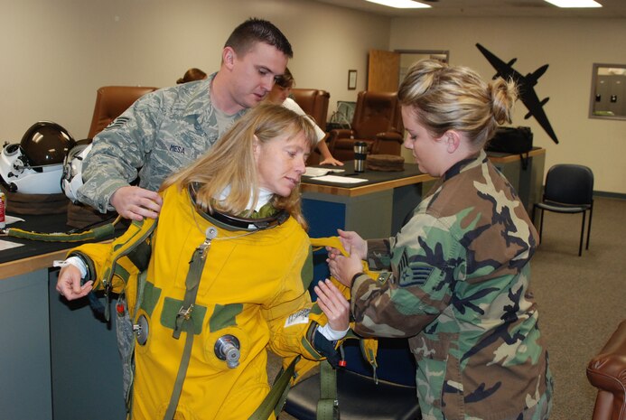 Staff Sgt. Joe Mesa, an Aerospace Physiological Training Flight life support technician, and Staff Sgt. Jennifer Gilroy, APTF NCO-in-charge of administration help Lane Wallace, a journalist with Flying magazine, suit up before her high flight Nov. 13 at the 9th Physiological Support Squadron. Two APTF Airmen assist with U-2 flyers while another Airman supervises to prevent mistakes. (Photo by Airman 1st Class Chuck Broadway)
