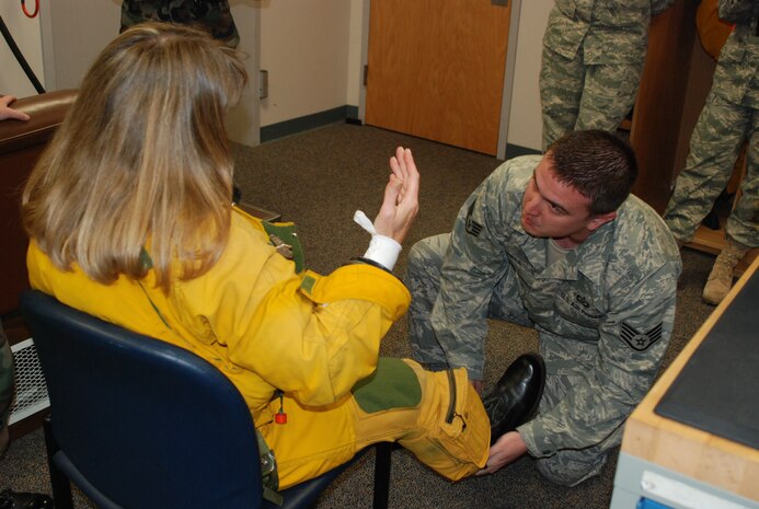 Staff Sgt. Joe Mesa, an Aerospace Physiology Training Flight life support technician, assists Lane Wallace, a journalist with Flying Magazine, Nov. 13 at the Physiological Support Squadron. Sergeant Mesa and other life support airmen help dress pilots for each mission. (Photo by Airman 1st Class Chuck Broadway)
