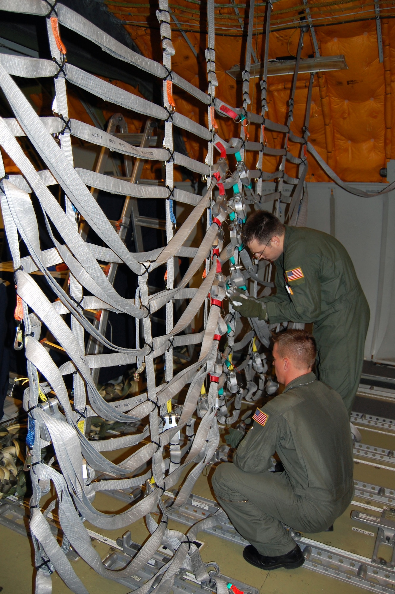 Boom operators from McGuire Air Force Base, N.J., install an alternative, lightweight cargo net inside a KC-10 Extender Sept. 16 as part of a demonstration for the Air Mobility Battlelab.  The demonstration was for the Battlelab's KC-10 Lightweight Cargo Net and Hoist Initiative which was recommended for use to Air Mobility Command.  It was one of the last initiatives of the AMB, which deactivated Sept. 24 at the U.S. Air Force Expeditionary Center on Fort Dix, N.J.  (U.S. Air Force Photo/Tech. Sgt. Scott T. Sturkol)