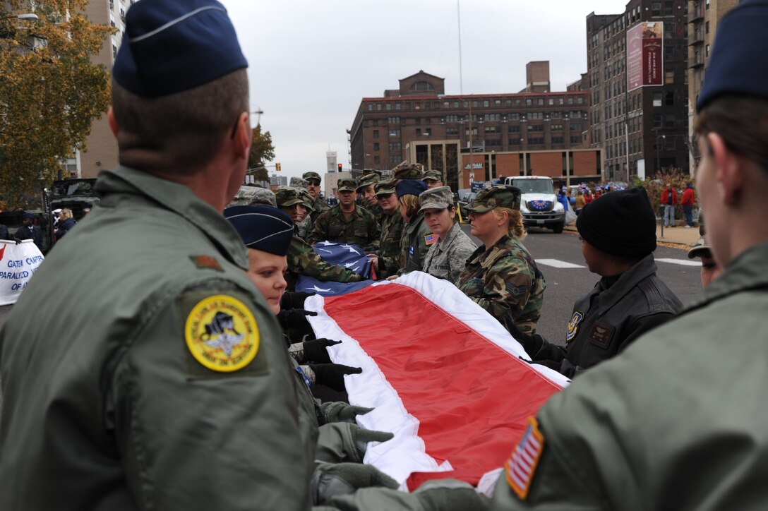 932nd Airlift Wing members gently unfold the gorgeous American flag to prepare it for the start of the St. Louis Veteran's Memorial Parade in November, 2008.  Staff Sgt. Kris Rasley said, "it is a priveledge to honor those who have sacrified so much for our freedom."  (U.S. Air Force photo/Tech. Sgt. Gerald Sonnenberg)