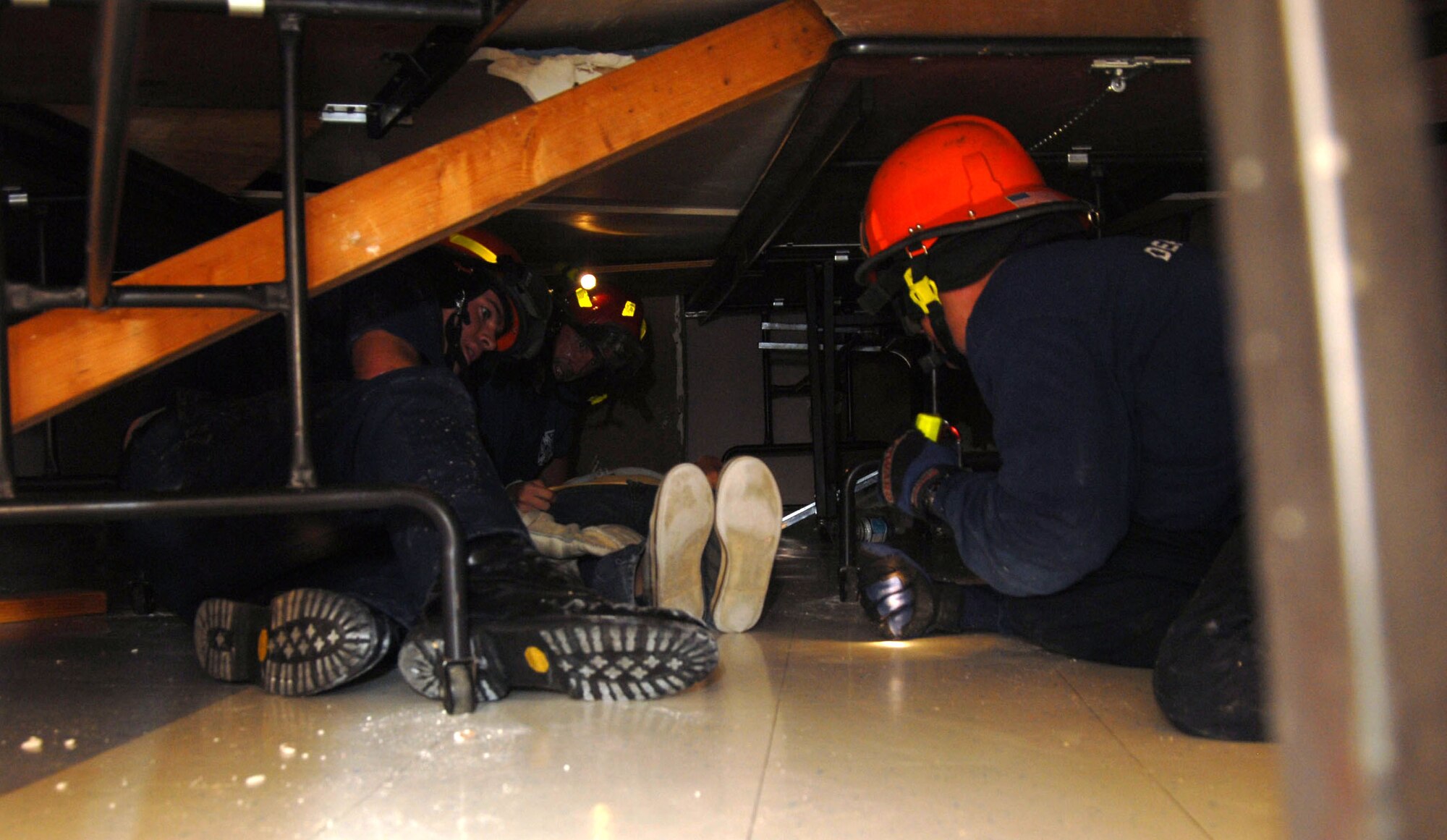 Edwards firefighters drag a victim under the rubble of a collapsed school building. Damaged was caused by a simulated magnitude 7.8 earthquake as part of the Great Southern California Shakeout. All of Edwards participated in the exercise, the largest earthquake preparedness activity in U.S. history. (Air Force photo by Senior Airman Julius Delos Reyes)
