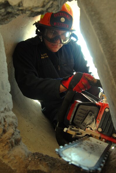 Matt Dennison, Edwards firefighter, drills a hole to make an entrance into a collapsed building caused by a simulated magnitude 7.8 earthquake as part of the Great Southern California Shakeout. (Air Force photo by Senior Airman Julius Delos Reyes)