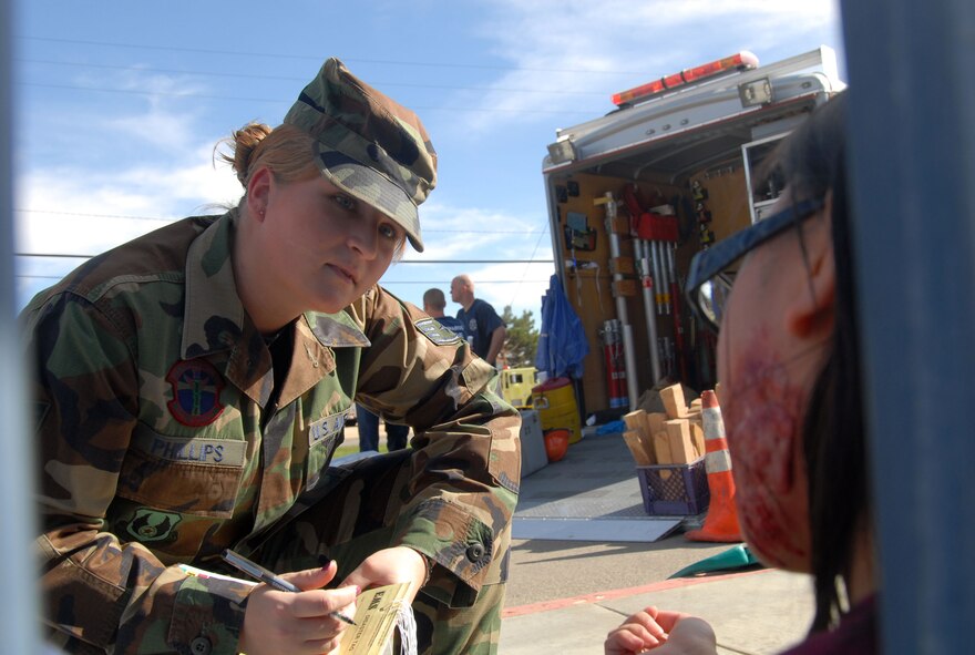 Staff Sgt. Sara Phillips, 95th Medical Support Squadron referral management technician, asks for information from an injured victim of a simulated magnitude 7.8 earthquake. This was part of the Great Southern California Shakeout, the largest earthquake exercise in California's history. (Air Force photo by Senior Airman Julius Delos Reyes) 