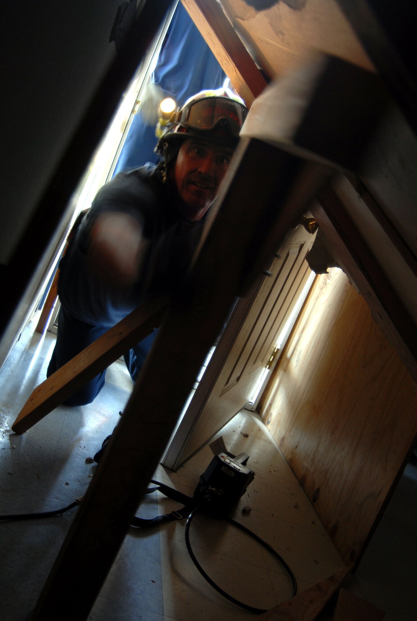 Don Scheller, Edwards lead firefighter places a wooden T-bar support on one of the collapsed walls of a school building that was affected by a simulated magnitude 7.8 earthquake. This was part of the Great Southern California Shakeout exercise. (Air Force photo by Senior Airman Julius Delos Reyes)