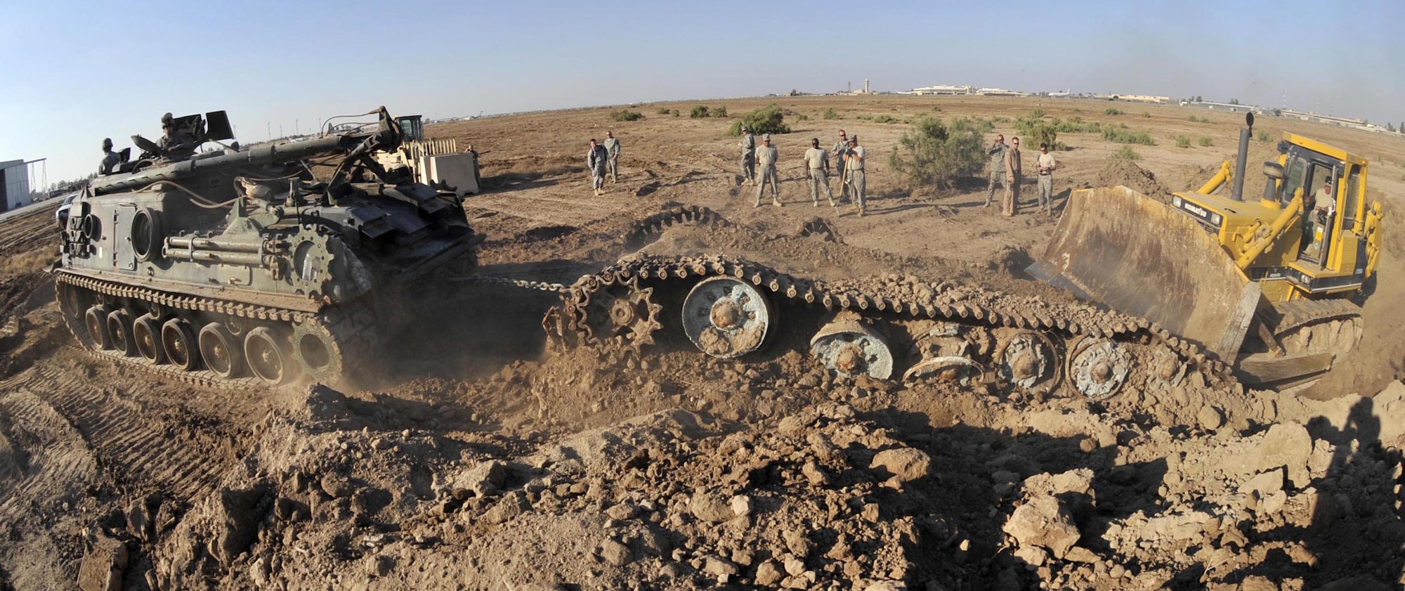 Airmen from the 447th Expeditionary Civil Engineer Squadron and Soldiers from the 503rd Maintenance Company work together with an M-88 tank recovery vehicle and a bulldozer pull and push an Iraqi T-72 Main Battle Tank from its grave on the airfield at Sather Air Base, Iraq. The tank was an obstruction to safe airfield operations and had to be removed. (U.S. Air Force photo/Master Sgt. Brian Davidson)