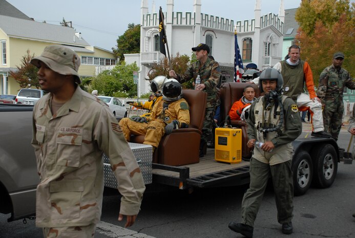 Airmen from the 9th Physiological Support Squadron march next to the unit's float, which showcase's their unique mission. (Photo by Staff Sgt. Sarah Gregory)