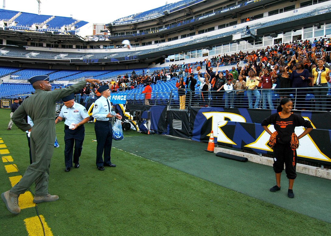 Brig. Gen. Alfred J. Stewart, Tech. Sgt. Stephen Sutton and Master Sgt. Christopher Claar toss free Air Force T-shirts to Baltimore City College High School football fans Nov. 8 at M&T Bank Stadium in Baltimore. A Class of 1977 Baltimore Polytechnic Institute High School alumni, General Stewart shared inspirational words with both teams before the game and he presented a $500 college scholarship to a member of both high schools. General Stewart is the Air Force Recruiting Service commander. Sergeants Sutton and Claar are assigned to the 317th Recruiting Squadron. (U.S. Air Force photo/Tech. Sgt. Jennifer Lindsey) 