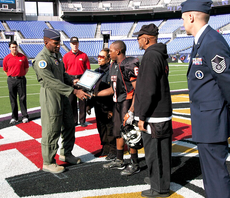 Brig. Gen. Alfred J. Stewart presents Malik Pack of Baltimore City College High School a $500 college scholarship before game time Nov. 8 at M&T Bank Stadium in Baltimore. A Class of 1977 Baltimore Polytechnic Institute High School alumni, General Stewart shared inspirational words with both teams before the game and he presented a $500 college scholarship to a member of both high schools. General Stewart is the Air Force Recruiting Service commander. (U.S. Air Force photo/Tech. Sgt. Jennifer Lindsey) 