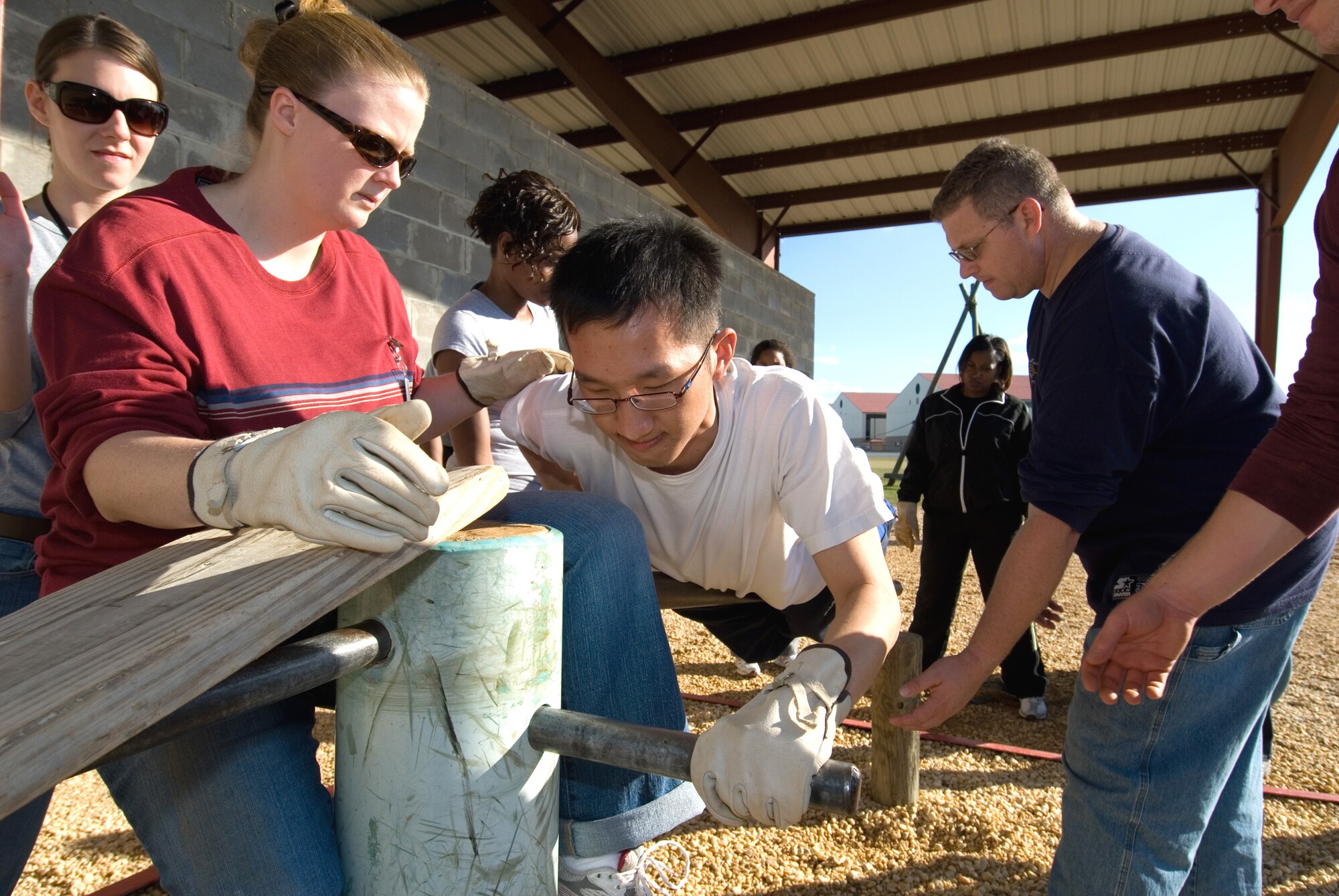 Civilian Acculturation and Leadership Training student Jana Ramon assists fellow student Eric Chan during a physical problem-solving exercise Nov. 3 at Maxwell Air Force Base, Ala. Students received two weeks of training at the Air Force Officer Training School. (U.S. Air Force photo/Jamie Pitcher) 
