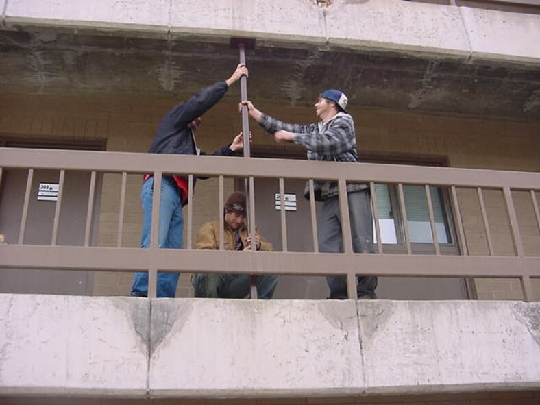 Workers working on walkway supports on Walkway/Handrail project at Bldg 357.