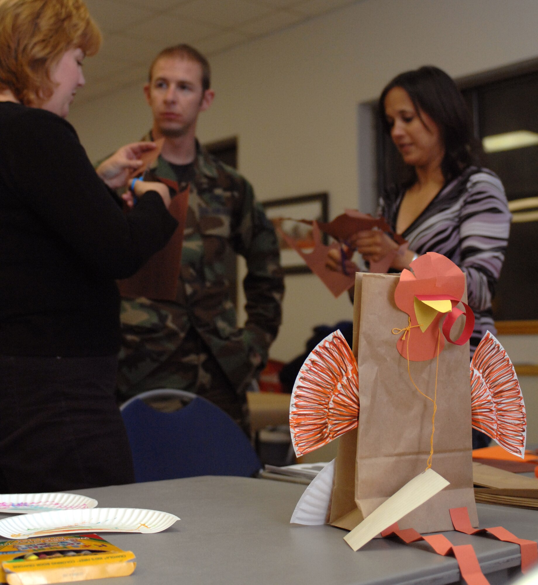 Parents who participated in the Families Apart Dinner at the Chapel at Holloman Air Force Base, N.M., Nov. 12, help their children create a paper Thanksgivings Day turkey by cutting out pieces for them. Holloman?s Key Spouses sponsored this Families Apart Dinner. They served a variety of soups, breads and drinks to those who participates and then held a craft-time for the children. (U.S. Air Force photo/Airman Sondra M. Escutia)