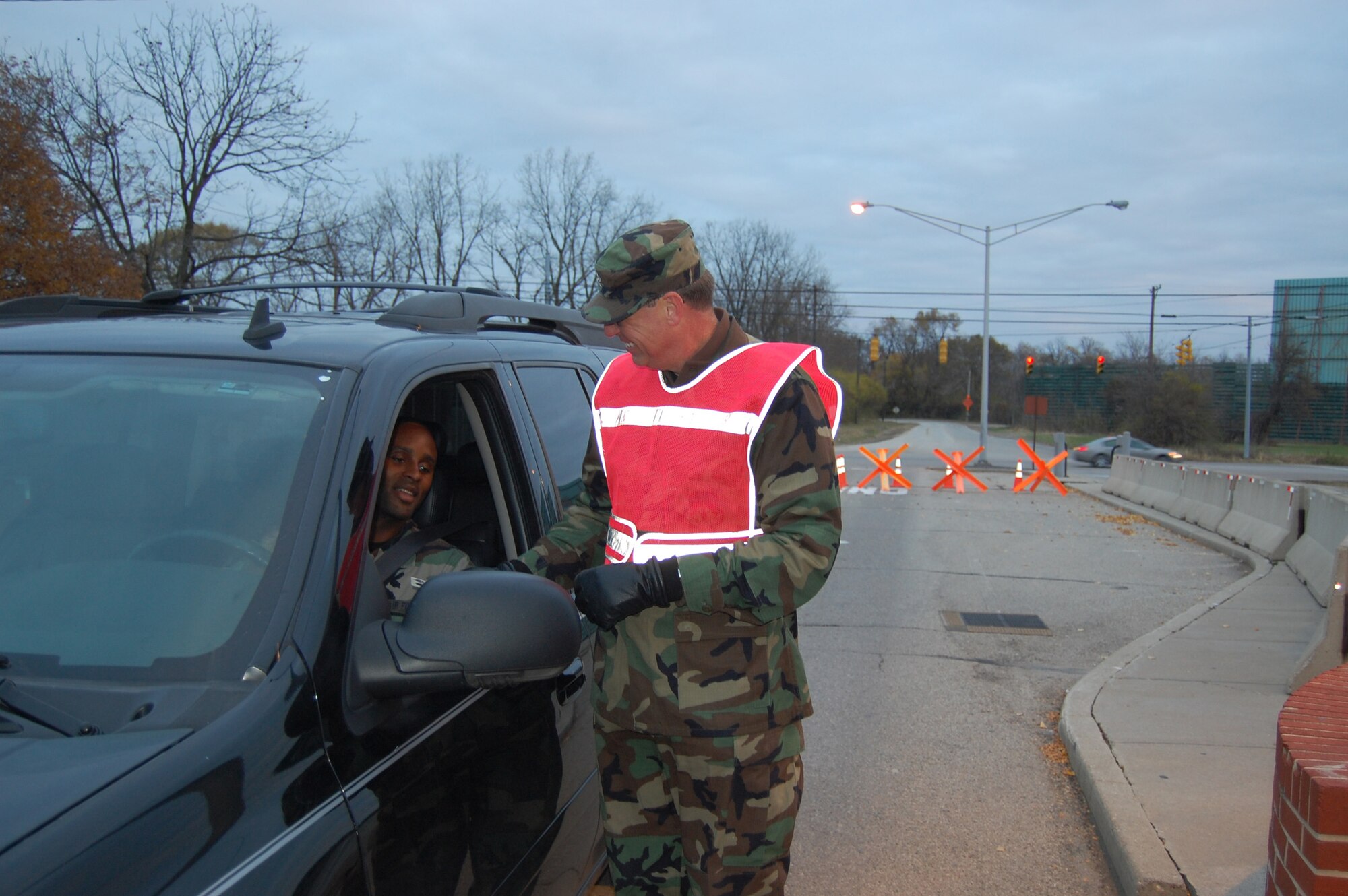 WRIGHT-PATTERSON AFB, Ohio - Col. Stephen Goeman, 445th Airlift Wing commander, checks Tech. Sgt. Robert Norsworthy's I.D. card as he enters Gate 26C for the 445th Airlift Wing's Unit Training Assembly.  Sergeant Norsworthy is a member of the 445th Mission Support Flight.  Col. Goeman assisted the 445th Security Forces Squadron members in checking I.D.s Saturday morning at Gate 26C. (Air Force photo/Maj. Cynthia Harris)