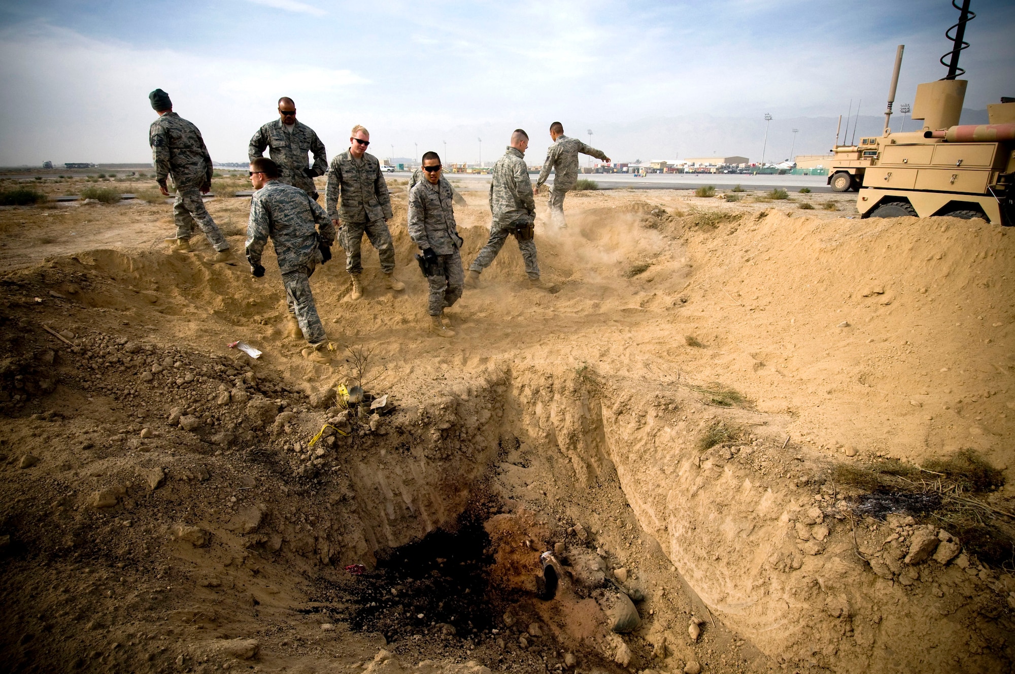 The 755th Air Expeditionary Group Explosive Ordnance Disposal team inspects a controlled burn on the flightline Nov. 7 at Bagram Airfield, Afghanistan. The dirt berm built-up around the site helped to provide a barrier in the event of a full-scale or premature detonation. (U.S. Air Force photo/Staff Sgt. Samuel Morse) 
