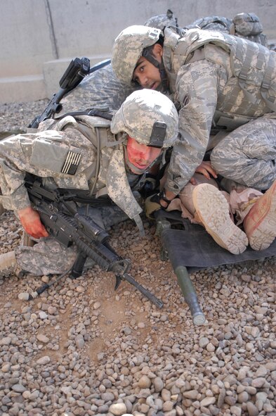 Airman 1st Class Jonathan Guzman, 532nd Expeditionary Security Forces Squadron, covers a roleplayer who was simulated wounded to protect him from further injury during a counter attack during training at Joint Base Balad, Iraq, Nov. 12. Airman Guzman a security forces apprentice deployed from Lackland Air Force Base, Texas, attended combat lifesaver training, which is a requirement for personnel in the 332nd Expeditionary Security Forces Group. U.S. Air Force photo/Tech. Sgt. Craig Lifton) 