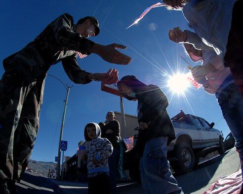 Airman 1st Class Collier Buffington, 49th Logisitics Readiness Squadron, Holloman Air Force Base, N.M., passes out candy to children during the Veterans Day parade Nov. 8, in Alamogordo, N.M. The Veterans Day National Ceremony is held Nov. 11 each year at Arlington National Cemetery.(U.S. Air Force photo/ Senior Airman Anthony Nelson)