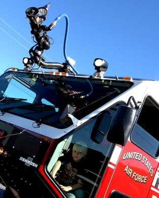 Team Holloman members escort a child in the Holloman Air Force Base, N.M., fire truck during the Veterans Day parade, Nov. 8, in Alamogordo, N.M.The Veterans Day National Ceremony is held Nov. 11 each year at Arlington National Cemetery. A color guard made up of members from each of the military services, renders honors to America's war dead during a tradition-rich ceremony at the Tomb of the Unkowns.(U.S. Air Force photo/ Senior Airman Anthony Nelson)
