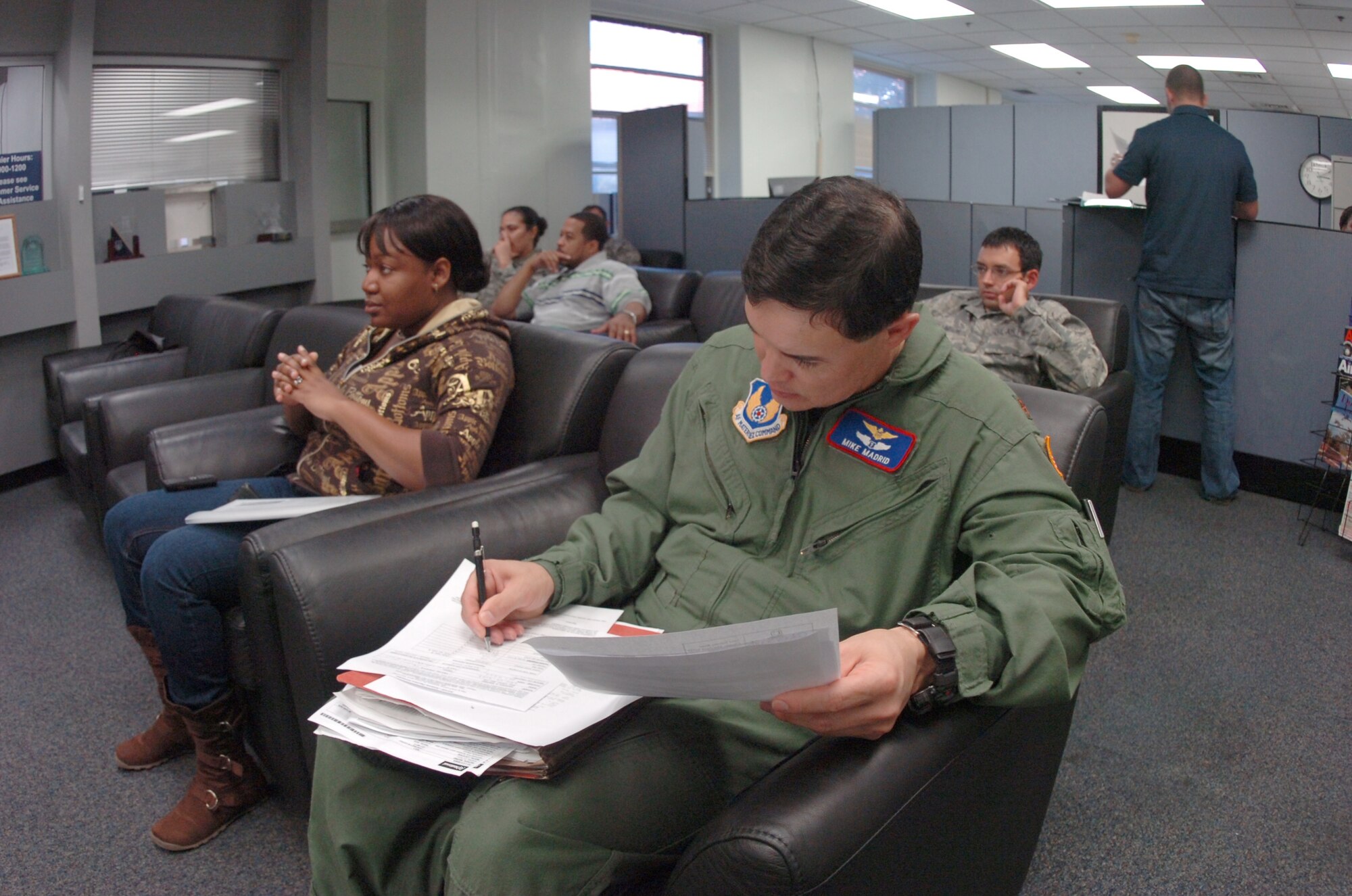 Major Mike Madrid, 779th Aeromedical Staging Flight, flight surgeon, figures out deployment travel pay, in the 316th Comptroller Squadron lobby area, while waiting for a financial service technician for assistance. The 316 CPTS services approximately 26,000 customers in all matters of travel, military pay, civilian pay and all budgetary activities for the wing commander. (U.S. Air Force photo by Bobby Jones)