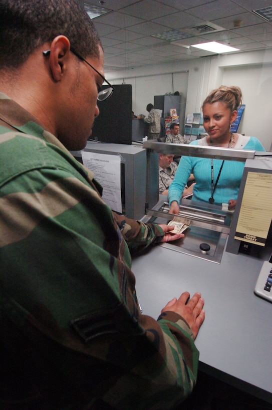 Airman 1st Class Rashad Noori, 316th Comptroller Squadron financial service technician cashier, receives a travel order payment from Staff Sgt. Chantal Brown, 459th Maintenance Squadron aircraft controller. The 316 CPTS services approximately 26,000 customers in all matters of travel, military pay, civilian pay and all budgetary activities for the wing commander. (U.S. Air Force photo by Bobby Jones)