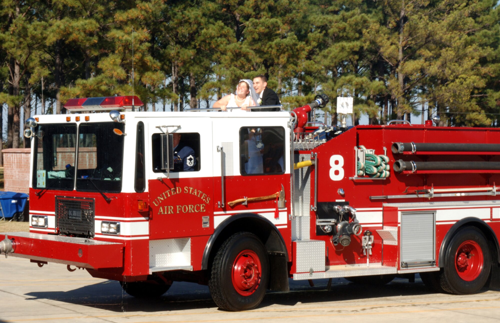 Airman 1st Class Michael White, 14th Civil Engineer Squadron, and his new bride, Laura, ride atop a Columbus AFB fire truck driven by Senior Master Sgt. Russell Eidenschink, 14th CES Superintendent, immediately following their wedding ceremony Nov. 9 at the Fire Department. (U.S. Air Force photo by Airman Josh Harbin)
